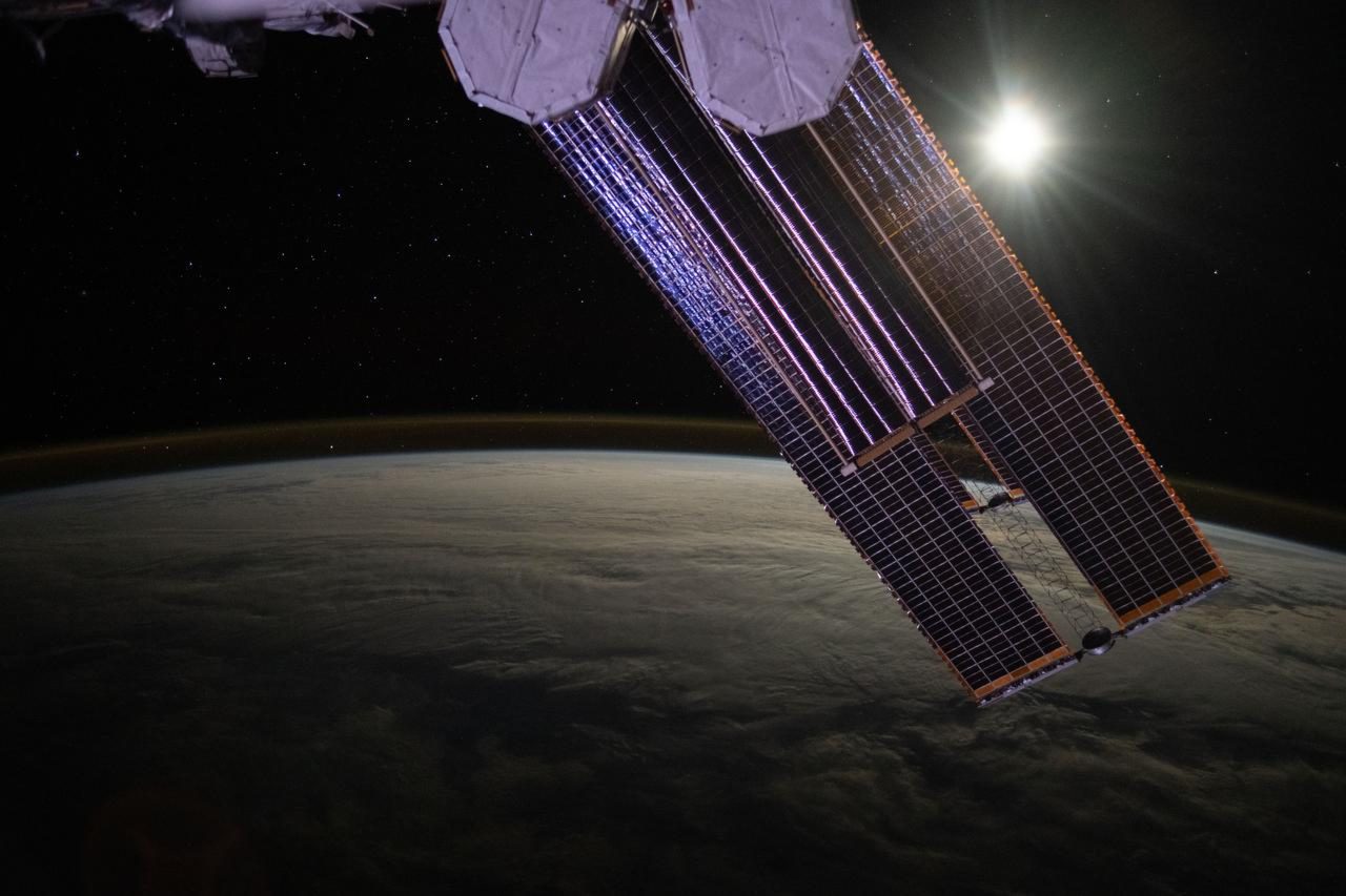 the moon illuminates a cloud-covered pacific ocean